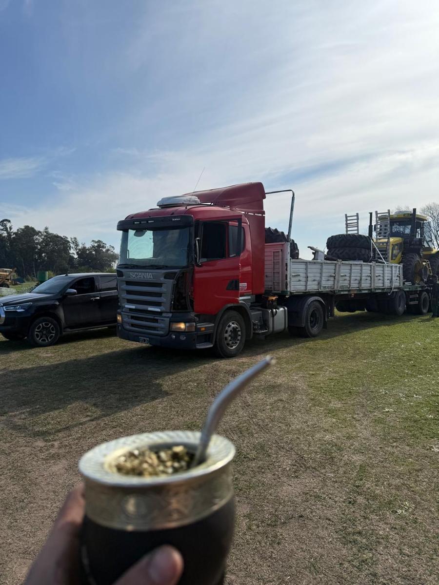 Semirremolque con barandas llevando maquinaria agrícola